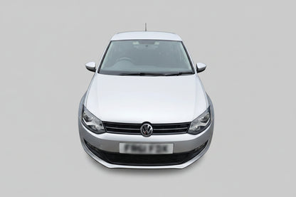 A silver Volkswagen Polo hatchback parked outdoors on a dirt lot, showing the front grille, headlights, and front license plate.